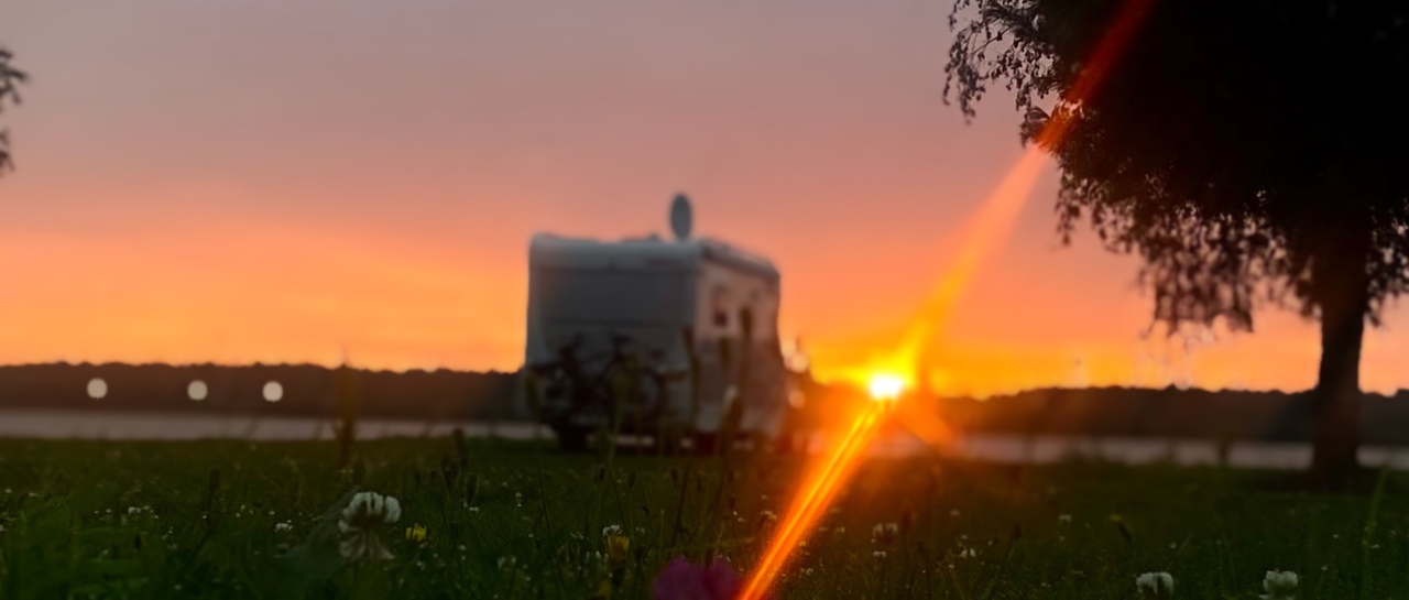 Matkailuauto Torandan caravan-alueella auringonlaskussa